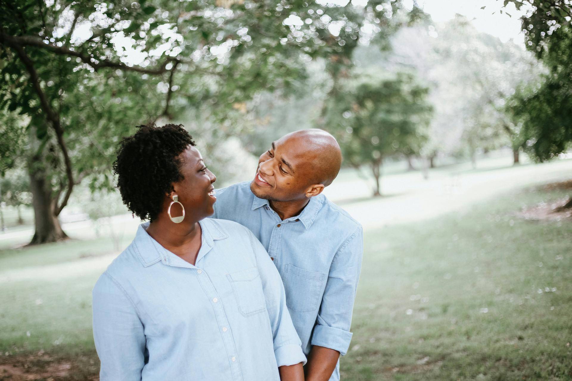 A man and a woman smiling at each other in a park
